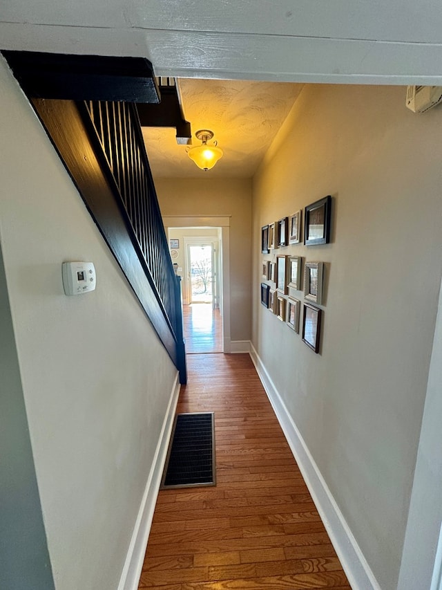 corridor with hardwood / wood-style floors