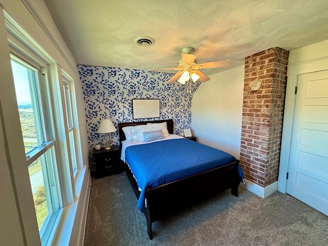 carpeted bedroom with ceiling fan and a textured ceiling