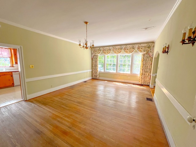 unfurnished room with a chandelier, light hardwood / wood-style flooring, and ornamental molding