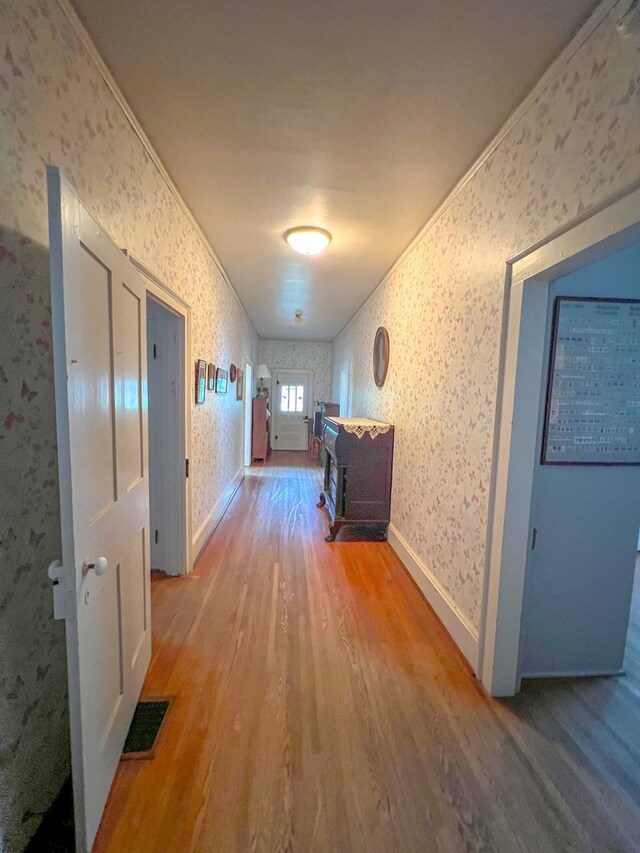 corridor with crown molding and hardwood / wood-style floors