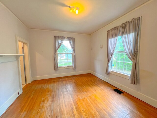 unfurnished room featuring wood-type flooring and crown molding