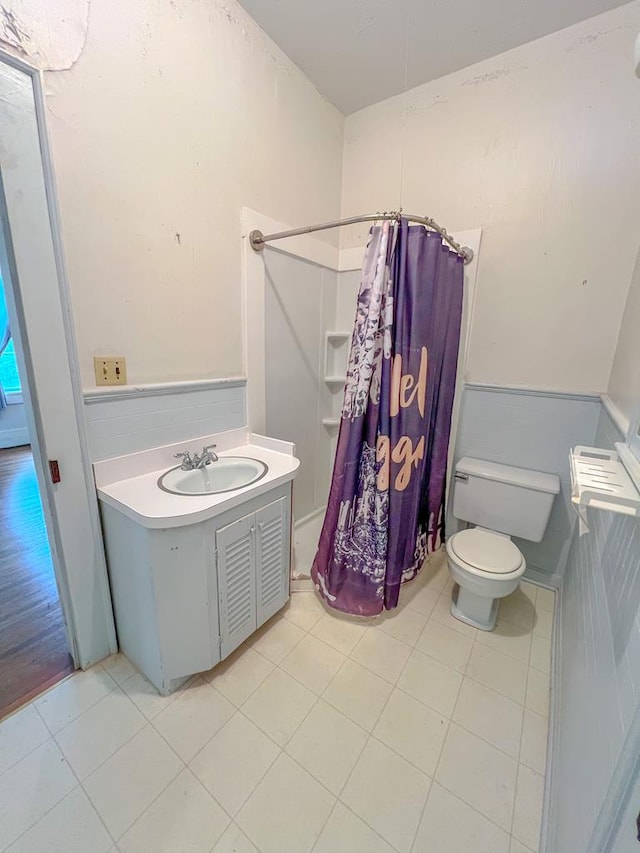 bathroom with vanity, toilet, walk in shower, and tile patterned flooring