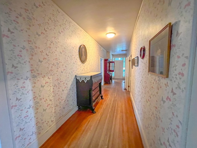 hallway with hardwood / wood-style flooring and ornamental molding