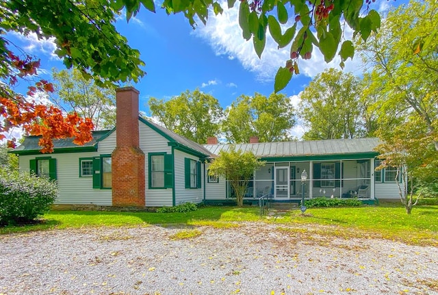 single story home featuring a sunroom and a front yard