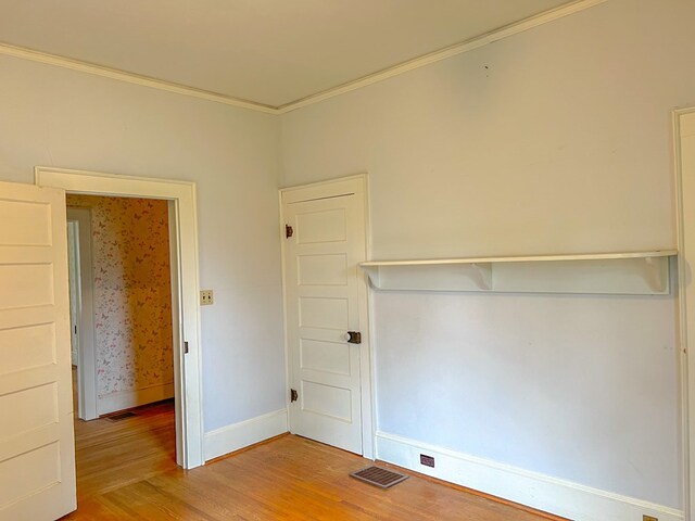 unfurnished room with hardwood / wood-style floors and ornamental molding