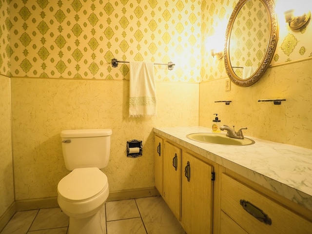 bathroom featuring toilet, vanity, baseboards, and tile patterned flooring