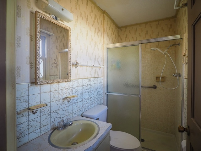 bathroom featuring vanity, toilet, a stall shower, and wallpapered walls