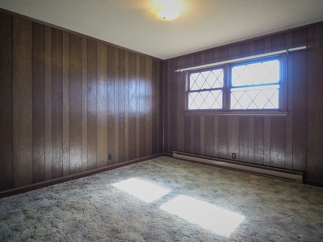 unfurnished room featuring wooden walls, carpet, and a baseboard heating unit