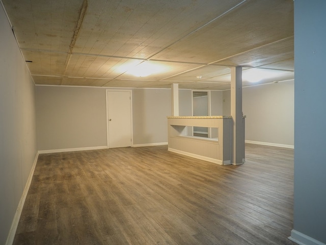 finished below grade area featuring wood finished floors and baseboards