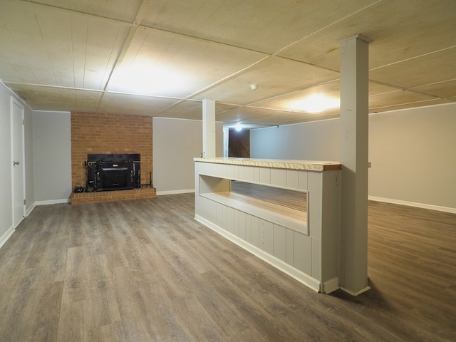 finished below grade area with baseboards and wood finished floors