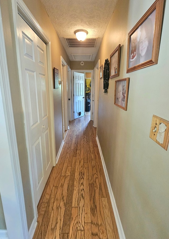 290 Hummingbird Hl, Tazewell, VA 24651 - hallway with wood finished floors, a textured ceiling, and baseboards