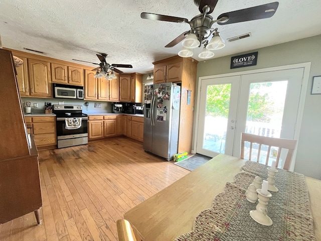290 Hummingbird Hl, Tazewell, VA 24651 - kitchen with appliances with stainless steel finishes, a ceiling fan, light wood-style floors, light countertops, and a textured ceiling