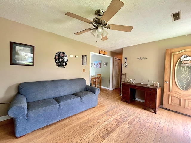 290 Hummingbird Hl, Tazewell, VA 24651 - living room with light wood finished floors, a textured ceiling, ceiling fan, and baseboards
