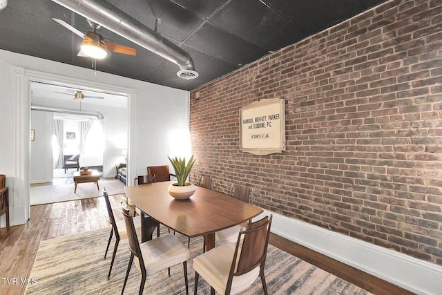 24 6th St, Bristol, TN 37620 - dining space featuring ceiling fan, wood finished floors, visible vents, baseboards, and brick wall