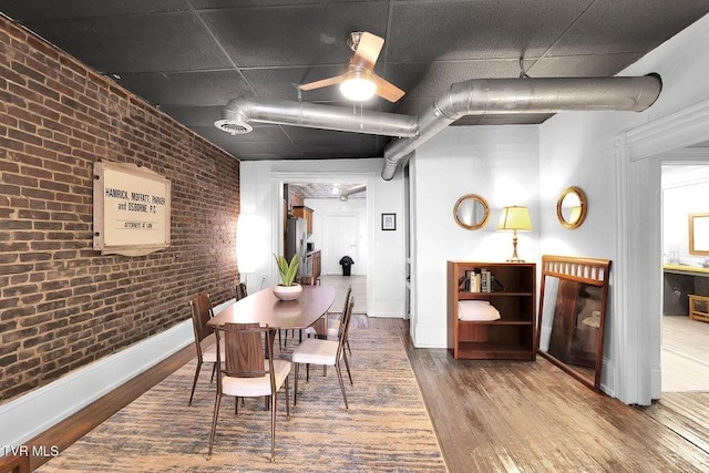 24 6th St, Bristol, TN 37620 - dining area with brick wall, baseboards, wood finished floors, and ceiling fan