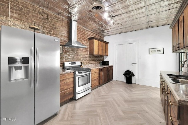 24 6th St, Bristol, TN 37620 - kitchen with wall chimney range hood, visible vents, an ornate ceiling, appliances with stainless steel finishes, and brick wall