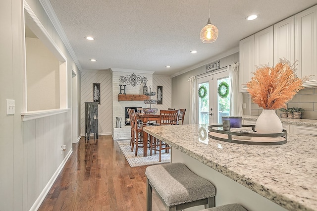 420 Brookwood Dr, Bristol, TN 37620 - kitchen featuring ornamental molding, french doors, dark wood-type flooring, wood walls, and a breakfast bar
