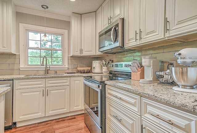 420 Brookwood Dr, Bristol, TN 37620 - kitchen with appliances with stainless steel finishes, crown molding, light stone counters, backsplash, and light wood-type flooring