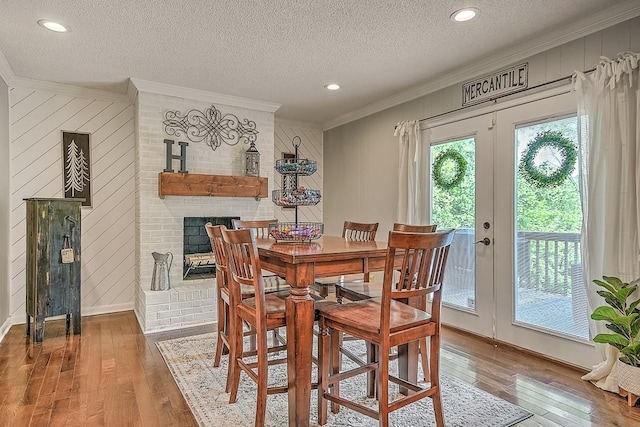 420 Brookwood Dr, Bristol, TN 37620 - dining area with crown molding, hardwood / wood-style floors, a textured ceiling, a brick fireplace, and wood walls
