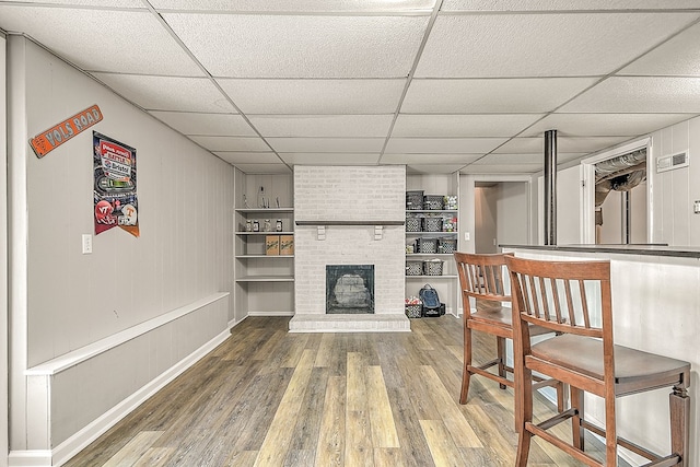 420 Brookwood Dr, Bristol, TN 37620 - living room featuring wood finished floors, a paneled ceiling, a fireplace, built in features, and bar area
