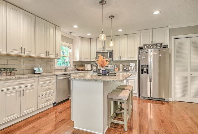 420 Brookwood Dr, Bristol, TN 37620 - kitchen with appliances with stainless steel finishes, ornamental molding, light wood-type flooring, white cabinetry, and a center island