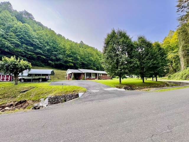 2989 Greenbrier Rd, Haysi, VA 24256 - view of front of property featuring asphalt driveway, a wooded view, a front yard, and a detached carport