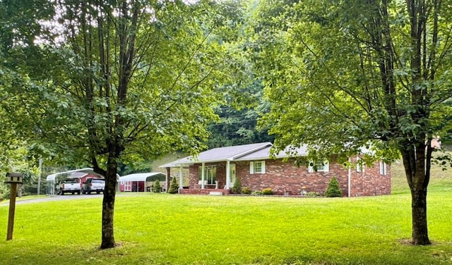 2989 Greenbrier Rd, Haysi, VA 24256 - view of front of house with a detached carport, a front yard, brick siding, and asphalt driveway