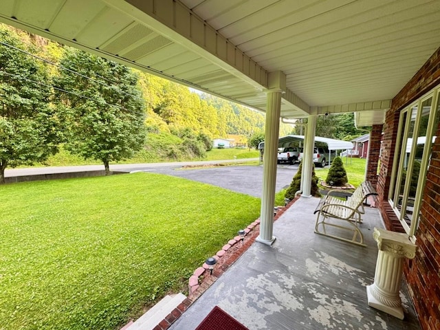 2989 Greenbrier Rd, Haysi, VA 24256 - covered porch featuring a lawn and a forest view