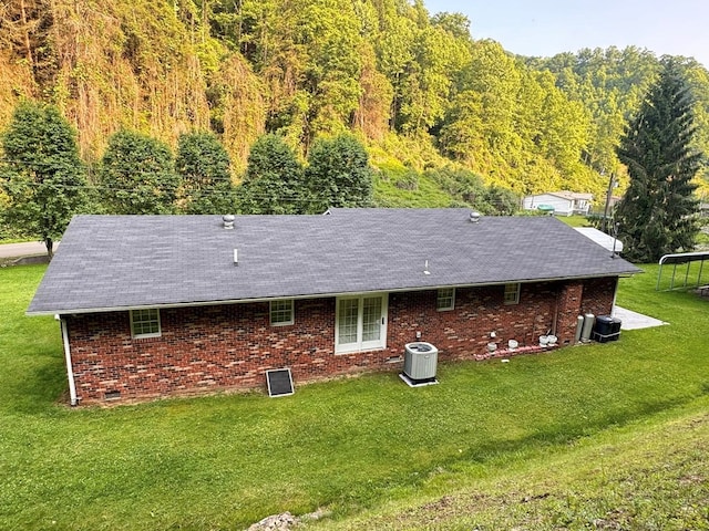 2989 Greenbrier Rd, Haysi, VA 24256 - rear view of property featuring brick siding, a lawn, a wooded view, and roof with shingles