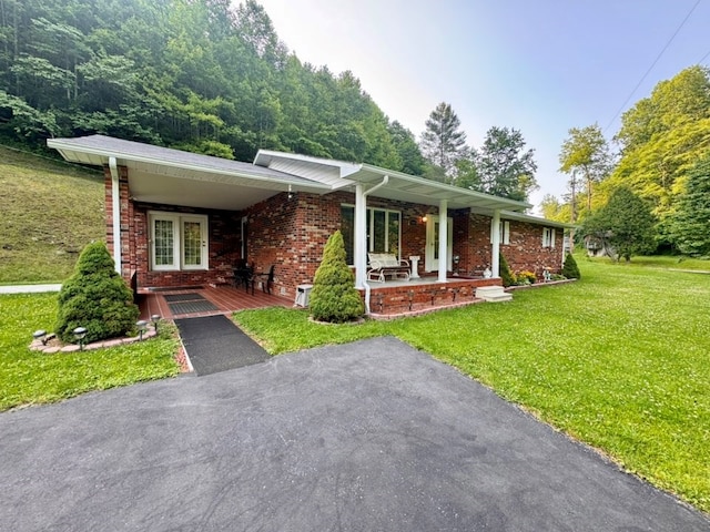 2989 Greenbrier Rd, Haysi, VA 24256 - ranch-style house featuring covered porch, brick siding, a front lawn, and an attached carport