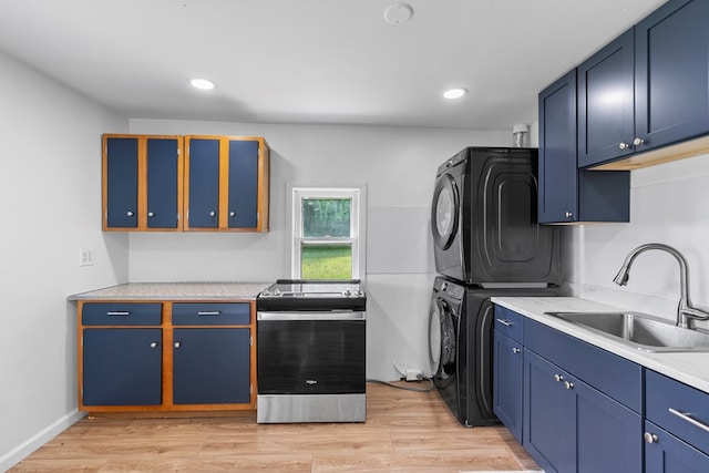 21468 Mandalay Ln, Abingdon, VA 24211 - kitchen with estacked washer and dryer, stainless steel electric range, light countertops, light wood-type flooring, and blue cabinets