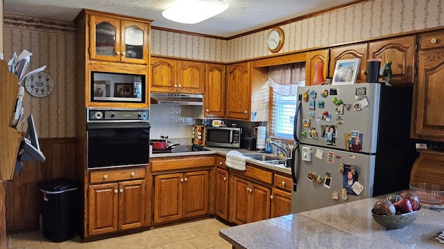 1359 Scratch Gravel Rd, Marion, VA 24354 - kitchen with black appliances, wallpapered walls, brown cabinets, wainscoting, and under cabinet range hood