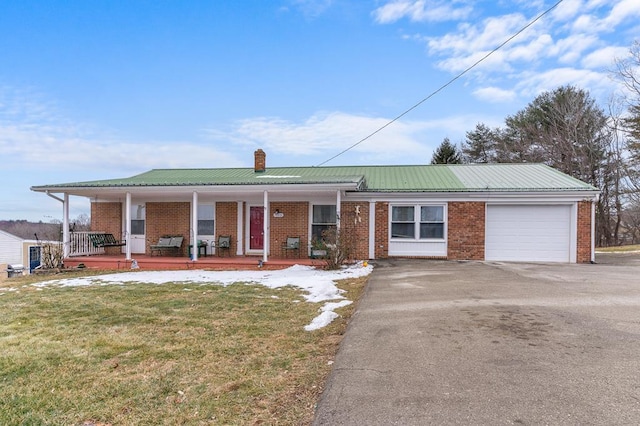 view of front of property with a garage, a front yard, and covered porch