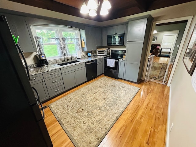 18335 Westwood Dr, Abingdon, VA 24211 - kitchen featuring black appliances, gray cabinetry, a chandelier, and light wood-style floors