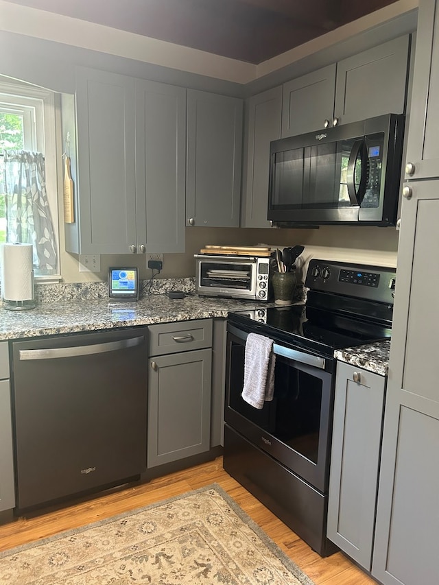 18335 Westwood Dr, Abingdon, VA 24211 - kitchen with dishwashing machine, black microwave, stainless steel range with electric cooktop, gray cabinetry, and light wood-type flooring