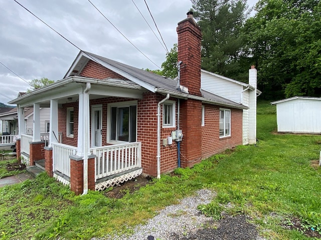 250 Staley St, Marion, VA 24354 - view of side of property featuring a chimney, a porch, brick siding, and a yard