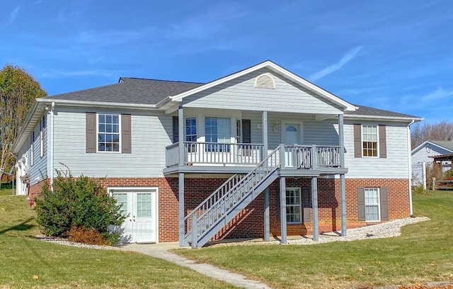 view of front of home with stairway, brick siding, covered porch, and a front yard