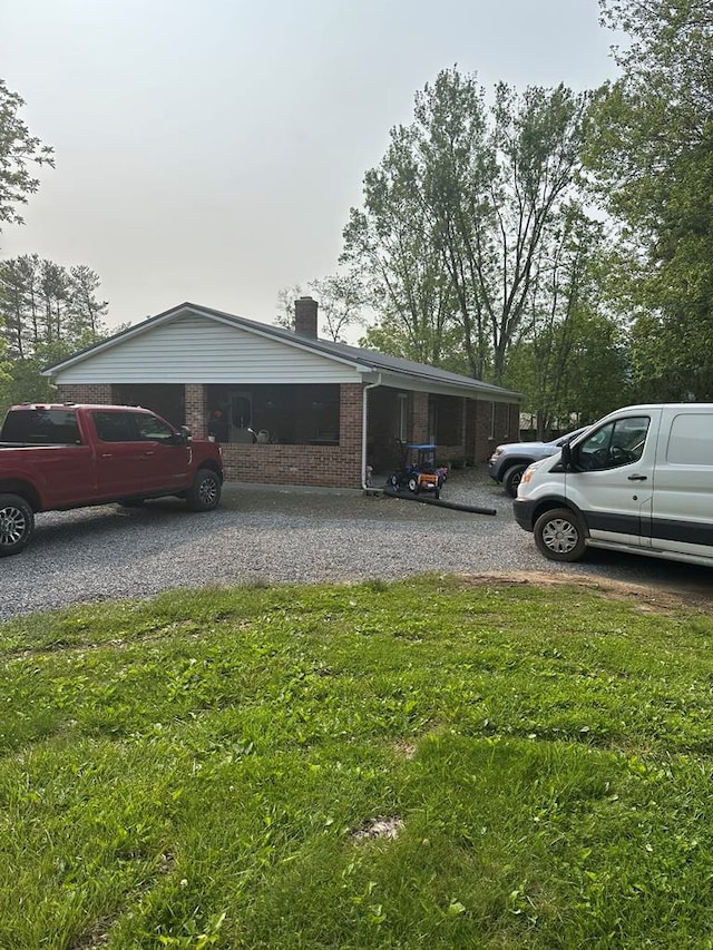 148 Rockspray Dr, Wytheville, VA 24382 - view of home's exterior featuring brick siding, a chimney, a lawn, and driveway
