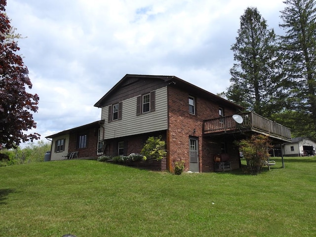 back of house with brick siding, a deck, and a lawn