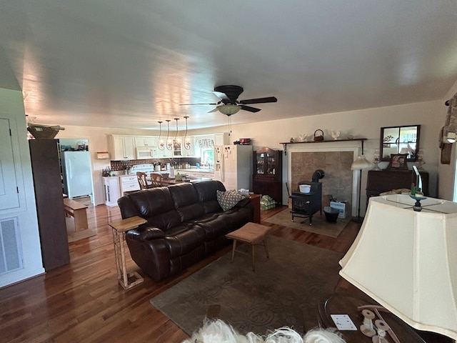 3950 Boyd Rd, Draper, VA 24324 - living area featuring a wood stove, a ceiling fan, and dark wood finished floors