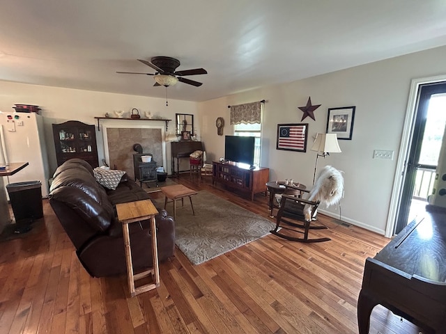 3950 Boyd Rd, Draper, VA 24324 - living room with a wood stove, healthy amount of natural light, wood-type flooring, and a ceiling fan