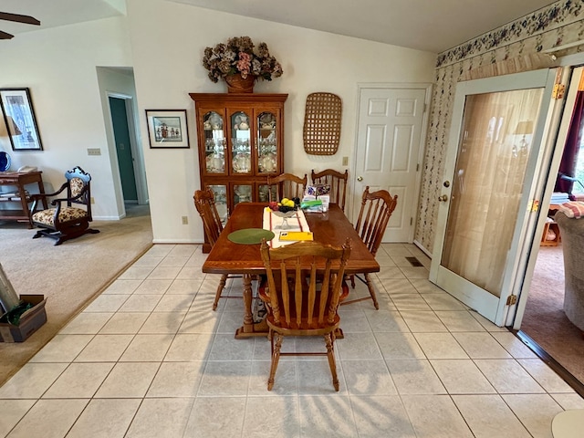 dining room featuring baseboards, ceiling fan, light tile patterned floors, and light carpet