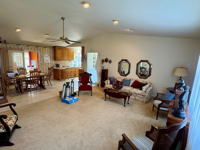 living room with light colored carpet, ceiling fan, and vaulted ceiling