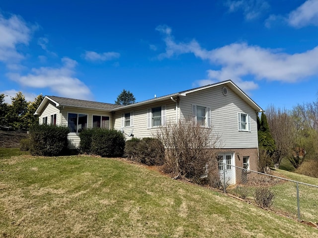 view of home's exterior with fence, a yard, and french doors