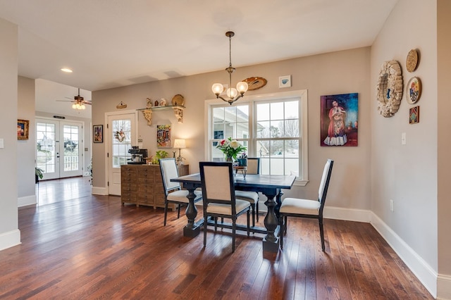 dining space with dark wood finished floors, a notable chandelier, french doors, and baseboards