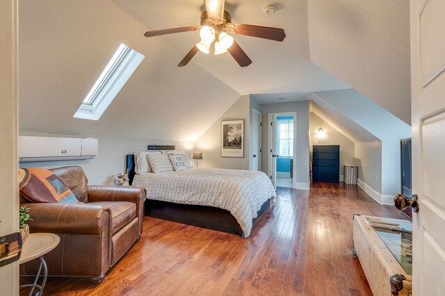 bedroom featuring vaulted ceiling with skylight, baseboards, ceiling fan, and hardwood / wood-style floors