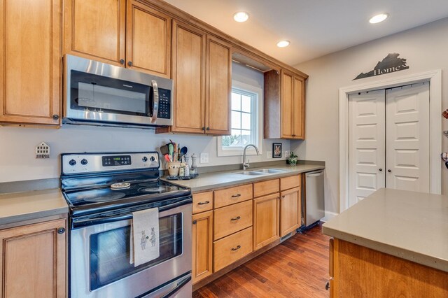 kitchen featuring light countertops, recessed lighting, wood finished floors, stainless steel appliances, and a sink