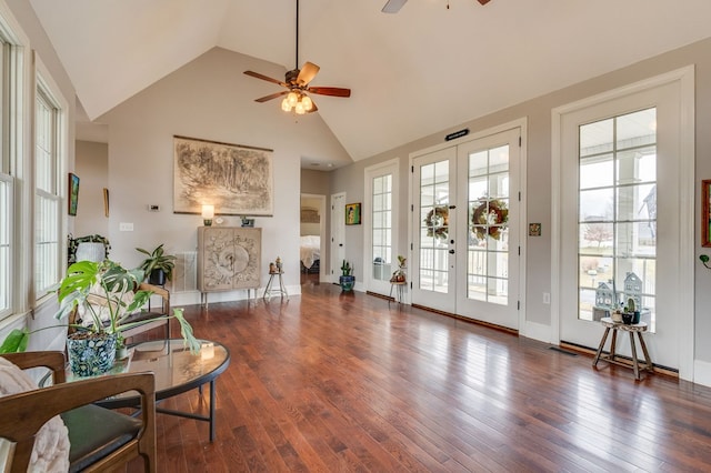 interior space with baseboards, french doors, high vaulted ceiling, a ceiling fan, and wood-type flooring