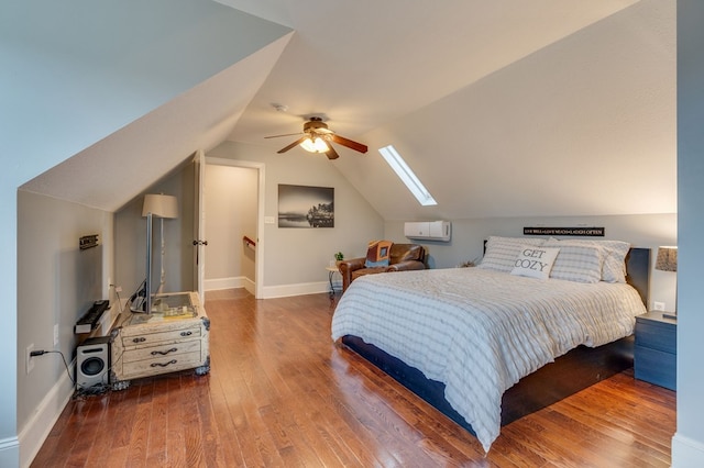 bedroom featuring baseboards, lofted ceiling with skylight, ceiling fan, and hardwood / wood-style flooring