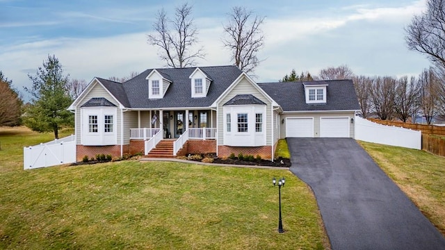 cape cod home with fence, aphalt driveway, a front yard, covered porch, and a gate